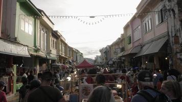 turistas lotados fazendo compras na estrada thalang no mercado de domingo à noite. vida no sudeste asiático video