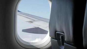 vista de dentro da cabine do avião pela janela com vista para o céu de nuvens video