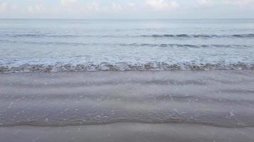 eau de vague de mer naturelle au ralenti avec de la mousse sur la plage de sable blanc de beauté, video