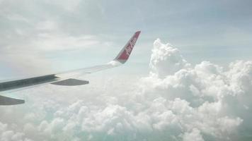 blick auf den airaisa airbus a320 flugzeugflügel durch das flugzeugfenster, das über die wolke fliegt video