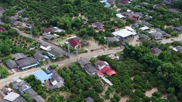 vista aérea de inundações em uma área residencial no norte da tailândia. a água do rio transborda após fortes chuvas e inunda áreas agrícolas e aldeias. video