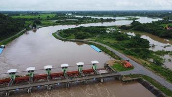 Aerial view of the water released from the concrete dam's drainage channel as the overflow in the rainy season. Top view of turbid brown forest water flows from a dam in rural northern Thailand. video