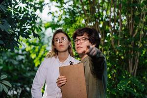 Young agricultural engineers working in big greenhouse photo