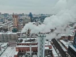 gran sala de calderas central con tuberías gigantes de las que hay humo peligroso en invierno durante las heladas en una gran ciudad foto