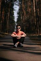 Handsome young man in white t-shirt and jeans outdoor in park, walking in the park photo