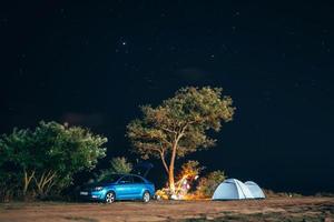 Group of five travellers rest on sea shore on evening sky background. photo