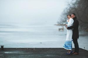 Beautiful couple on the dock in the winter fog. photo