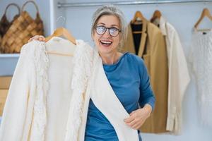 anciana durante elige suéter blanco en casa foto