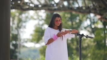 Young beautiful woman looks at smartphone in the park photo