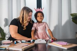 Mother and child daughter draws creatively at the table photo