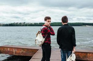 two young guys stand on the pier photo