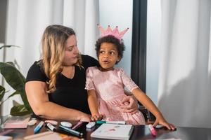 Mother and child daughter draws creatively at the table photo