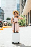 Portrait of young woman with suitcase and looking at camera photo
