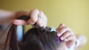 Process of braiding. Master weaves braids on head in a beauty salon, close up photo