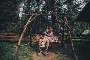 beautiful couple together with dog on a swing photo