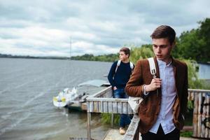 two young guys standing on a pier photo