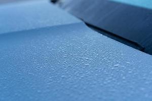 Raindrops on the hood of the car. Close-up. photo