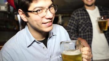 tipo con una cerveza en un bar con amigos un sábado por la noche foto