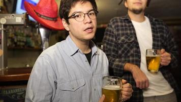 Guy with a beer in a bar with friends on a Saturday night photo