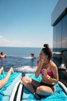 Young beautiful woman in swimsuit sunbathes on a sun lounger photo