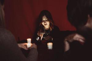 Group of people and woman fortune teller with crystal ball photo