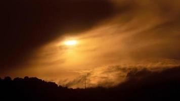 timelapse van dramatisch zonsondergang met oranje lucht in een bewolkt dag.
