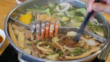 Vista de video de 4k mientras se pone carne rebanada de cerdo en hotpot shabu shabu