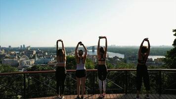 Sport girls on the background of the big city. Athletic young women doing morning exercises. photo