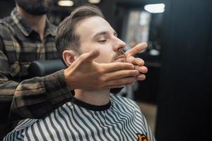 Facial applying lotion after shave in Barber shop. photo