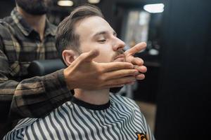 aplicación de loción facial para después del afeitado en la peluquería. foto