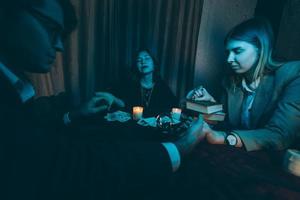 People hold hands of night at table with candles photo