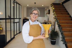 Happy senior woman showing pasta on camera. photo