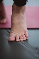 Cerrar detalle de pies de mujer durante el ejercicio de yoga. foto