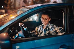 Woman driving car by night in the city photo