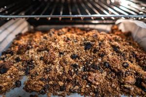 granola to cook in an electric oven. concept of simple ingredients for healthy breakfast photo