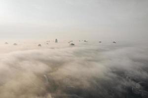 Aerial view of the city in the fog. Skyscrapers above the fog photo