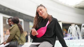 Woman using smartphone indoor. Texting and communicating in mall photo