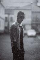 Portrait of carefree handsome young man is feeling free under the rain photo