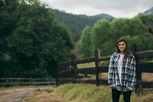 A young attractive Caucasian female sitting on a fence photo