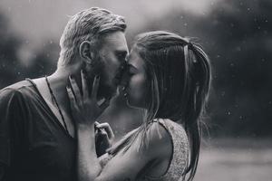 beautiful couple kissing in the rain photo