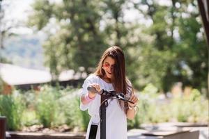 Young beautiful woman and an electric scooter, ecological transport photo