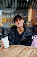 retrato de una joven hermosa mujer sentada en un café al aire libre foto