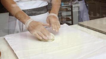 A man prepares an apple strudel for sale. Prepares the dough photo