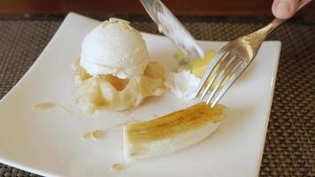 utilizzando forchetta per mangiare croffle su piatto con ghiaccio crema e caramello Banana. video