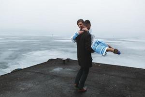 hermosa pareja en el muelle en la niebla invernal. foto