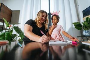 Mother and child daughter draws creatively at the table photo