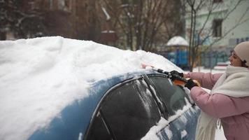 Woman removing snow from car photo