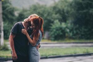 beautiful couple hugging in the rain photo