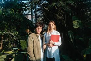 Young agricultural engineers talk in greenhouse photo