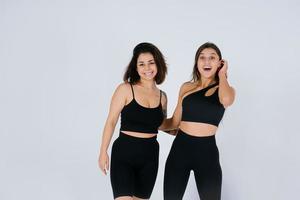 Two young women posing over white background. photo